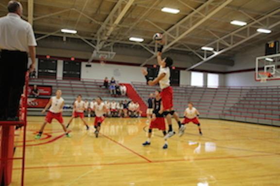 Sophomore outside hitter Kyle Carpenter rises up to slam the ball down for a kill against Center Grove. Carpenter and the Rebels beat Center Grove in three sets.