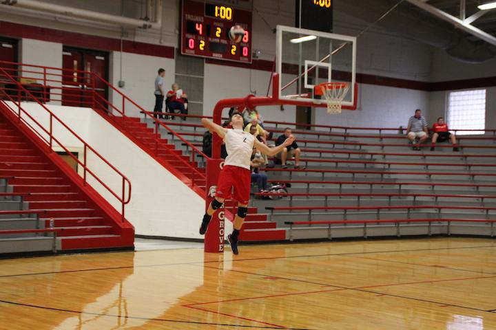 Senior setter Jacob Allard rises up to send a jump serve over the net at Center Grove. The Rebels went on to beat the Trojans in 3 sets.