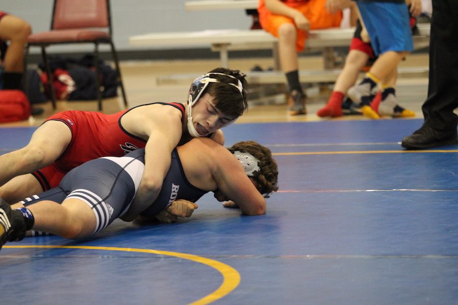 TAKE 'EM DOWN: Senior Josh Hiatt wrestles sophomore Max Quebe in an intersquad meet at St. Roch. The meet gave many Rebels the opportunity to practice and prepare for their season.  