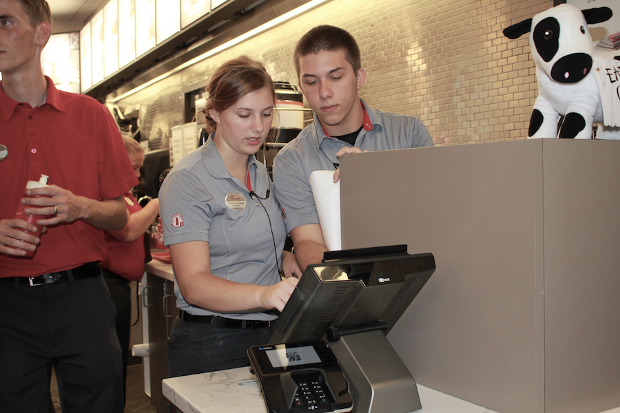 PROCESSING%3A+Senior+Alex+Woods+%28right%29+works+behind+the+counter+during+the+Chick-fil-A+challenge.+Woods+is+a+front+house+leader%2C+which+is+the+equivalent+of+a+manager.