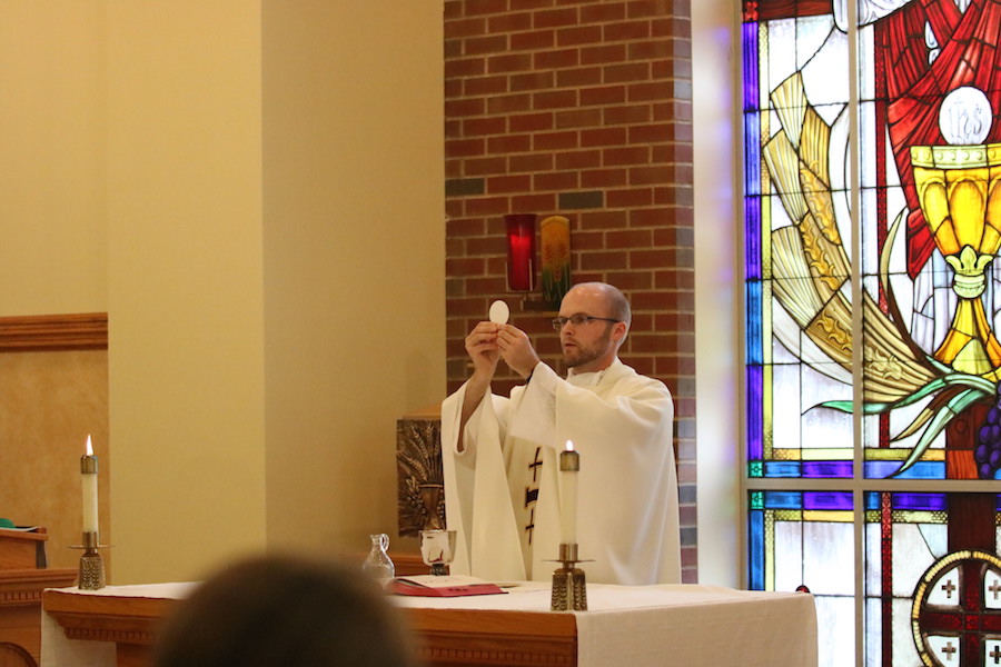 FEATURING%3A+Fr.+Dave+Marcotte+holds+the+consecrated+host+at+mass+during+fifth+period+study.+Fr.+Dave+gives+mass+during+a+study+period+most+days+of+the+week.+