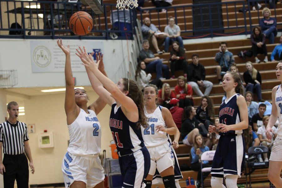 REBEL REBOUND: Senior Katelyn McClary extends her arms for a quick rebound over Perry Meridian star Sadie Hill. The Lady Rebels won the game, their season opener, over the Falcons 60-35.