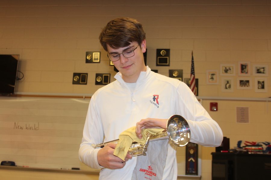 JUST LIKE NEW: Junior Henry Schutte cleans his trumpet for his next band practice. Instruments like this will be gathered from local musicians in the Indianapolis area to be refurbished.