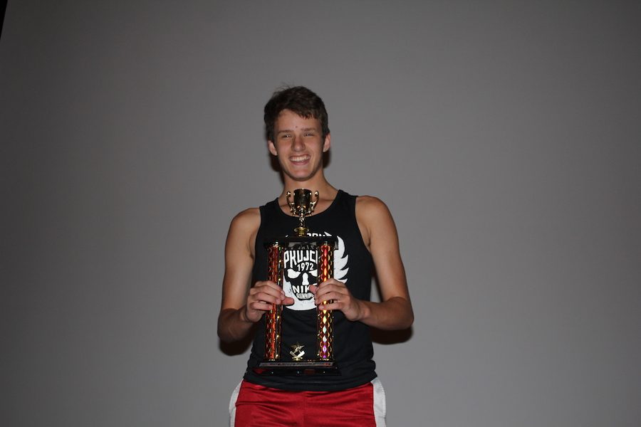 HUMBLE CHAMP: Junior Gabe Buening poses with his trophy in celebration of his victory. Buening took home first place in the Melee bracket of the tournament.