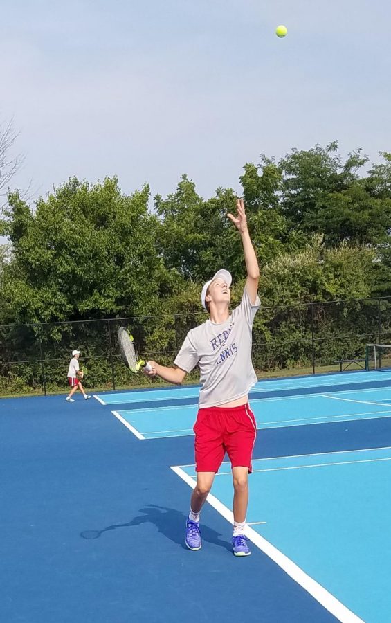 Senior Austin Schofield serves in his first match of the season. The Rebels beat the Flashes with a combined score of 3-2.