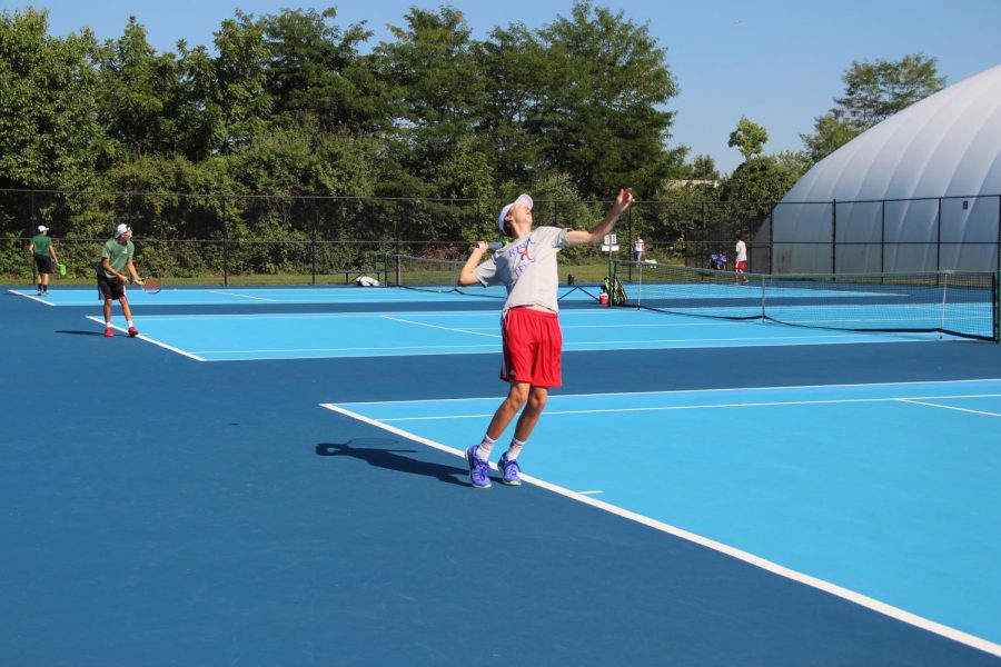 SERVING IT UP: Senior Austin Schofield warms up for the Rebels' match against Covenant Christian.