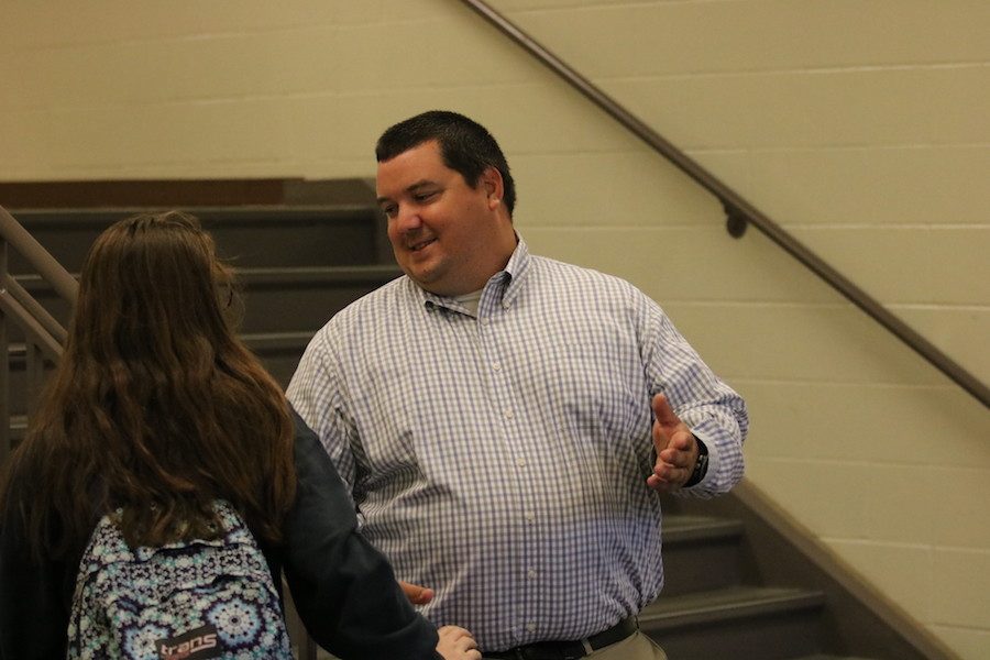 GOOD MORNING, HOW ARE YOU?: Director of campus ministry Jeff Traylor converses with students as they arrive at school. Traylor was one of the teachers that volunteered to be a greeter in the morning.