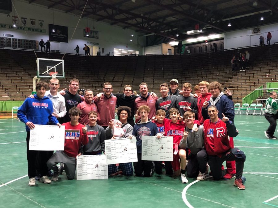 NUMBER ONE, BABY: Roncalli wrestlers celebrate their first place win. Senior Elijah Mahan holds Coach Wade McClurgs baby in celebration.