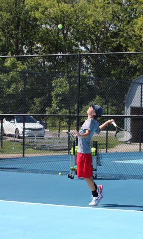 BALLS TO THE WALL: Senior Ty Ransburg prepares to slam a serve past his opponent. Ransburg, a veteran of the tennis team, will play a critical role in helping the team advance to another sectional win.
