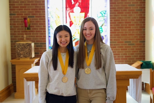 BOLD IN GOLD: Seniors Anne Ameis and Katrina Gangstad smile in the chapel after being named the class’s Valedictorian and Salutatorian. The two celebrated the honors they received with their families.