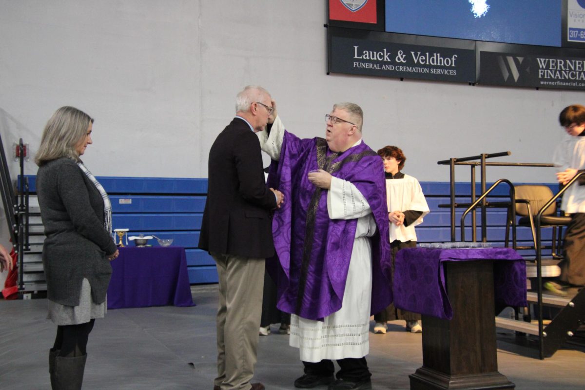 Father Bob Robeson applies ashes on President Chuck Weisenbach during Mass on Ash Wednesday.
