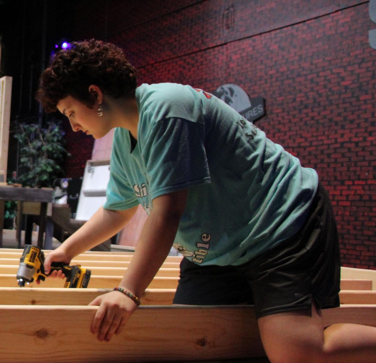 Senior Lily Babb helps to build the set for the production of “The Christmas Story” on stage during the 2023-2024 school year. Babb worked as a member of the stage crew before becoming a student director for the production of “Matilda.” 