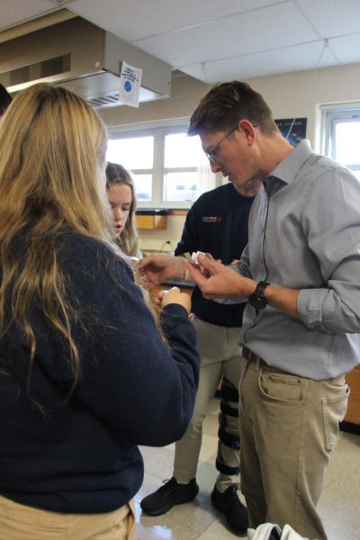 Mr. Greg Jansen demonstrates an experiment for his 6th period class. 