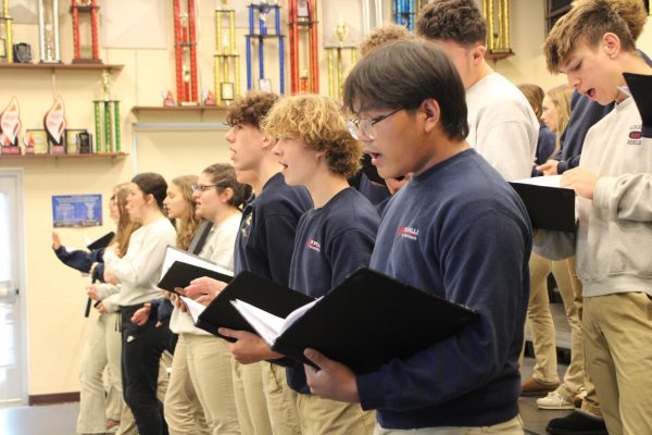 Senior Bawi Sang, sophomore Isaac Timberlake , and sophomore JP Miller  warm up for their song.