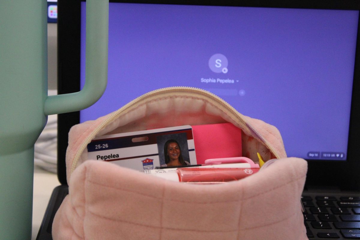 STAYING ORGANIZED: Sophia Pepelea places her student ID in her pencil bag. After she bought lunch, in order to not lose it, she zipped it up in her pencil case while she did her school work and chatted with friends.