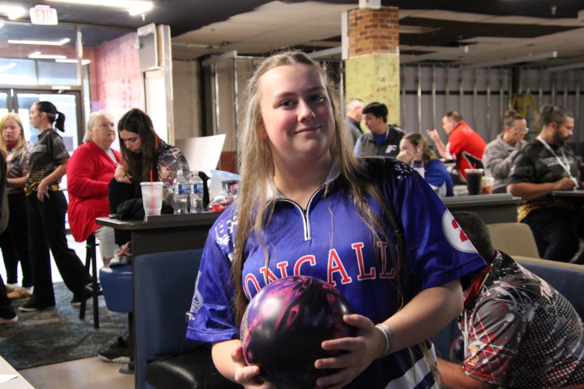 Senior Alison Holden poses with her bowling ball before her match against Center Grove. Holden helped lead the team to a win by bowling the high game of 197. 